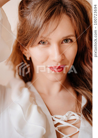 portrait of a beautiful woman in a white sexy dress with lacing and ruffles portrait of a beautiful woman in a white sexy dress with lacing and ruffles 100723694