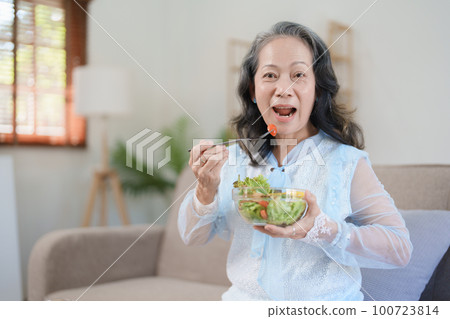 Portrait of an elderly Asian woman taking care of her health by eating salad 100723814