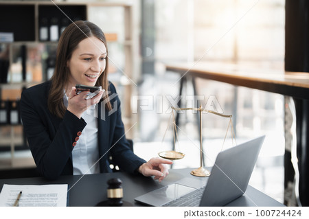 Portrait of a Asian woman lawyer studying lawsuit a for a client using smartphone , documents and computer to work before going to court Portrait of a Asian woman lawyer studying lawsuit a for a client using smartphone , documents and computer to work before going to court 100724424