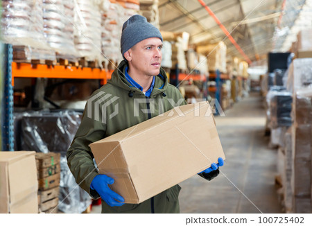 Man worker carrying cardboard box 100725402
