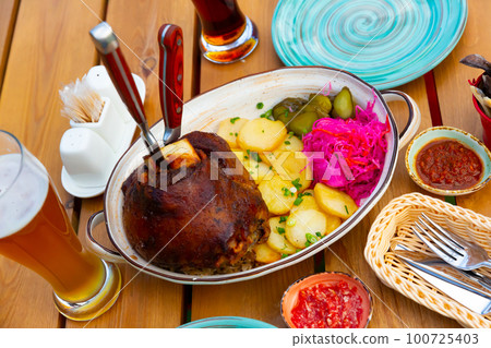 Roasted pork knuckle with potato and pickles 100725403