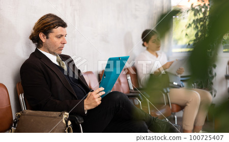 Portrait of serious man waiting for job interview while sitting at office lobby 100725407
