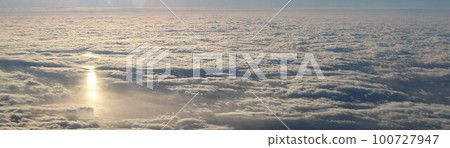 Sea of clouds and sun reflection from above 100727947
