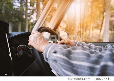 司機握著汽車的方向盤/司機的手在路上 100728310