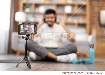 Fitness blogger recording video for sports vlog on phone Fitness blogger recording video for sports vlog on phone 100729632
