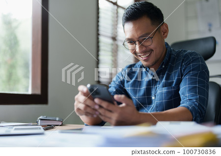 Portrait of a male business owner using a mobile phone. Portrait of a male business owner using a mobile phone. 100730836