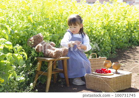A girl in a field of rapeseed flowers playing with nature A girl in a field of rapeseed flowers playing with nature 100731745