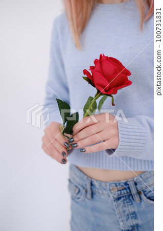 Attractive woman holding a red rose in her hands. Self love concept Attractive woman holding a red rose in her hands. Self love concept 100731831