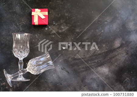 Two glasses with red gift box on dark background 100731880