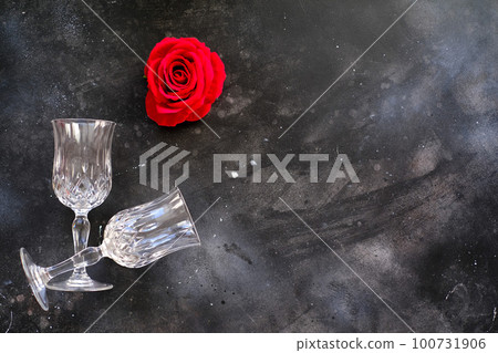 Two glasses with red rose nearby on dark background 100731906