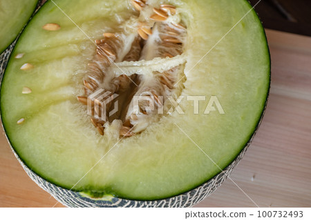 成熟甜甜的哈密瓜。部分切成兩半。 100732493