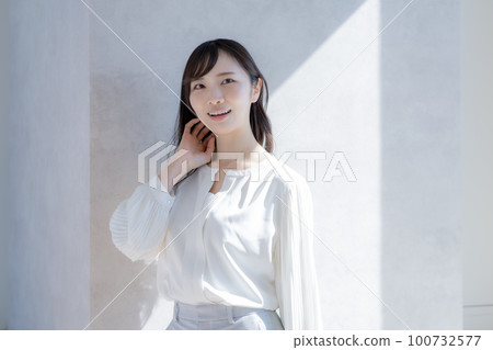 白色背景中穿著白色襯衫的年輕女子的畫像 100732577