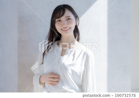 白色背景中穿著白色襯衫的年輕女子的畫像 100732578
