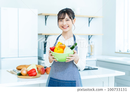 廚房裡拿著沙拉碗的年輕女人 100733131
