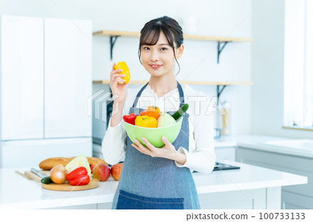 廚房裡拿著沙拉碗的年輕女人 100733133