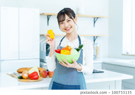 廚房裡拿著沙拉碗的年輕女人 100733135