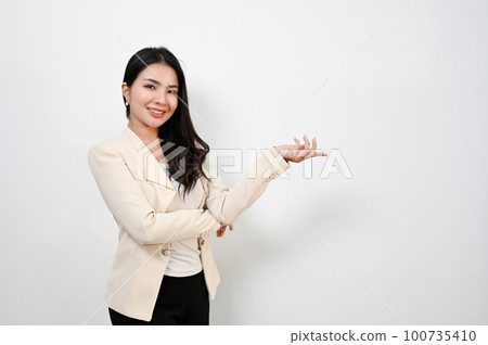 Smiling Asian businesswoman opens her palm in a friendly welcome gesture 100735410