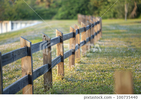 Wooden fence barrier at farm grounds for cattle and territory protection Wooden fence barrier at farm grounds for cattle and territory protection 100735440
