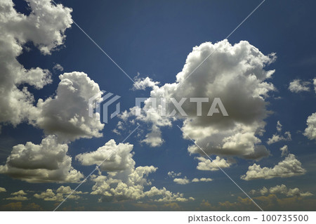 White puffy cumulus clouds on summer blue sky White puffy cumulus clouds on summer blue sky 100735500