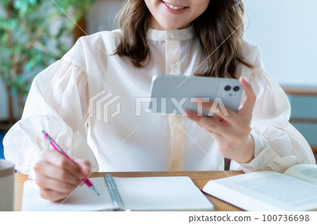 通過在智能手機上觀看視頻學習的女性 [部分剪切] 100736698