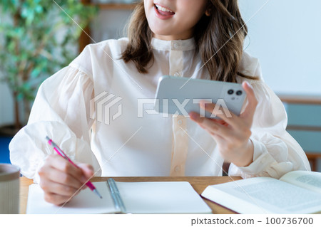 通過在智能手機上觀看視頻學習的女性 [部分剪切] 100736700
