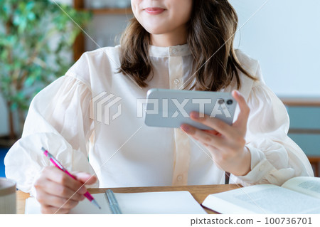 通過在智能手機上觀看視頻學習的女性 [部分剪切] 100736701