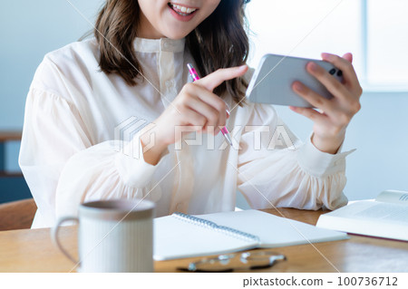 A woman studying by watching a video on a smartphone [parts cut] 100736712