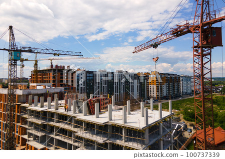 Tower crane at high concrete residential building under construction. Real estate development concept. 100737339