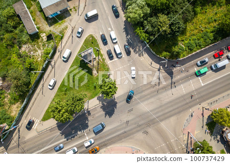 Top down aerial view of busy street intersection with moving cars traffic. 100737429