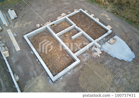 Top down aerial view of building works of new house concrete foundation on construction site 100737431