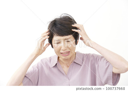 Middle-aged woman holding her head on a white background Middle-aged woman holding her head on a white background 100737668