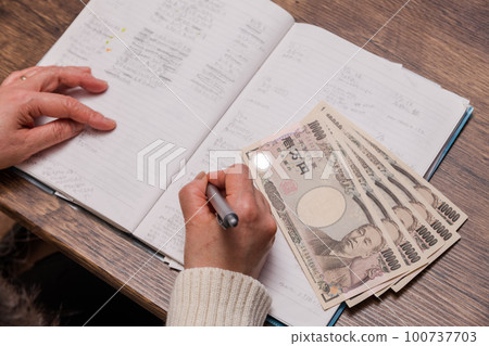 【拿著戶口簿和1萬日元鈔票的家庭主婦】 【拿著戶口簿和1萬日元鈔票的家庭主婦】 100737703