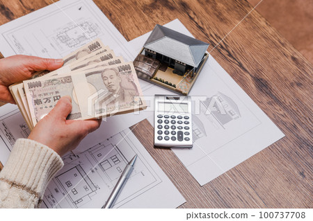 [A housewife doing calculations for purchasing a home] 100737708