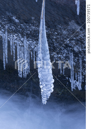 Blue shining icicles and frozen streams 100739571