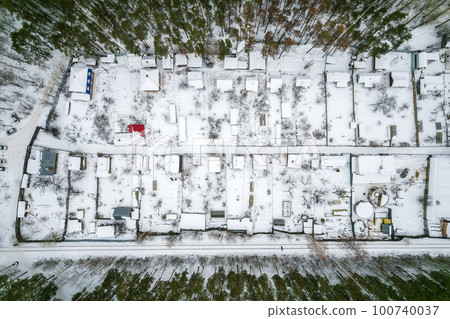 Aerial view of coniferous winter forest and a small houses.. Flying above frozen trees and snow covered ground of dense forest and a small houses for glamping. Aerial view of coniferous winter forest and a small houses.. Flying above frozen trees and snow covered ground of dense forest and a small houses for glamping. 100740037