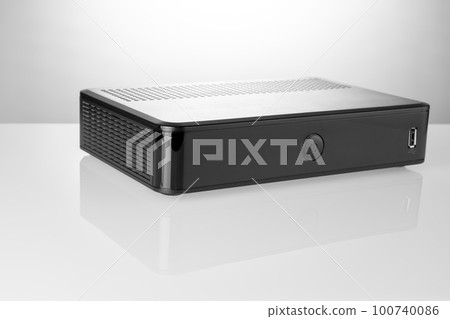 TV set-top box prepared for installation, digital TV kit on white background close-up with reflection 100740086