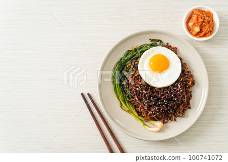 dried Korean spicy black sauce instant noodles with fried egg and kimchi 100741072