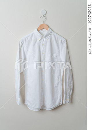 hanging shirt with wood hanger on wall 100742058