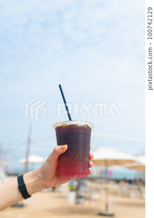 hand holding iced americano coffee 100742129