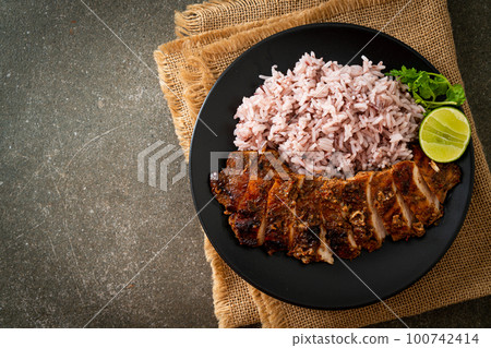spicy grilled Jamaican jerk chicken with rice 100742414