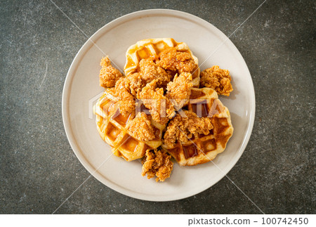 fried chicken waffle with honey or maple syrup fried chicken waffle with honey or maple syrup 100742450