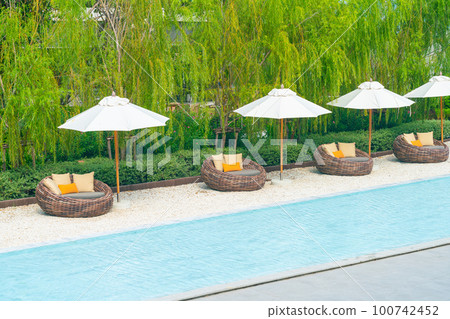 outdoor patio chair with pillow and umbrella around swimming pool outdoor patio chair with pillow and umbrella around swimming pool 100742452