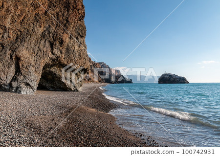 calm azure sea and volcanic rocky shores. Small waves on water surface in motion blur. Nature summer ocean sea beach background. Nobody. Holiday, vacation and travel concept calm azure sea and volcanic rocky shores. Small waves on water surface in motion blur. Nature summer ocean sea beach background. Nobody. Holiday, vacation and travel concept 100742931