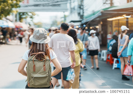 woman traveler visiting in Bangkok, Tourist with backpack and hat sightseeing in Chatuchak Weekend Market, landmark and popular attractions in Bangkok, Thailand. Travel in Southeast Asia concept woman traveler visiting in Bangkok, Tourist with backpack and hat sightseeing in Chatuchak Weekend Market, landmark and popular attractions in Bangkok, Thailand. Travel in Southeast Asia concept 100745151