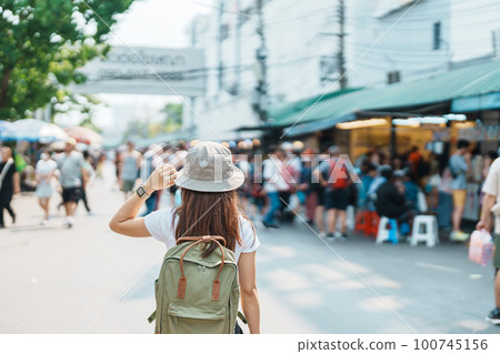 woman traveler visiting in Bangkok, Tourist with backpack and hat sightseeing in Chatuchak Weekend Market, landmark and popular attractions in Bangkok, Thailand. Travel in Southeast Asia concept woman traveler visiting in Bangkok, Tourist with backpack and hat sightseeing in Chatuchak Weekend Market, landmark and popular attractions in Bangkok, Thailand. Travel in Southeast Asia concept 100745156