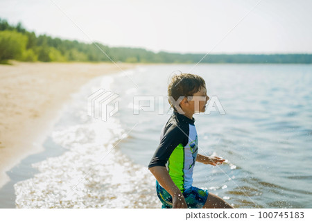 cute caucasian boy running into water with splashes and laughter. Happy childhood cute caucasian boy running into water with splashes and laughter. Happy childhood 100745183