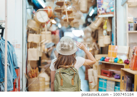 woman traveler visiting in Bangkok, Tourist with backpack and hat sightseeing in Chatuchak Weekend Market, landmark and popular attractions in Bangkok, Thailand. Travel in Southeast Asia concept woman traveler visiting in Bangkok, Tourist with backpack and hat sightseeing in Chatuchak Weekend Market, landmark and popular attractions in Bangkok, Thailand. Travel in Southeast Asia concept 100745184