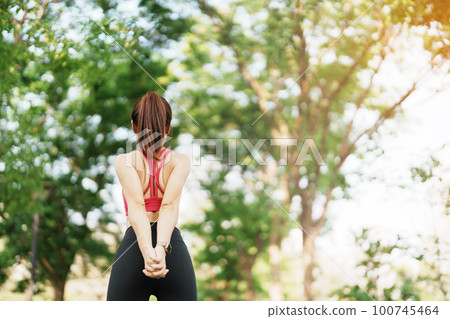 Young adult female in pink sportswear stretching muscle in the park outdoor, sport woman warm up ready for running and jogging in morning. wellness, fitness, exercise and work life balance concepts Young adult female in pink sportswear stretching muscle in the park outdoor, sport woman warm up ready for running and jogging in morning. wellness, fitness, exercise and work life balance concepts 100745464