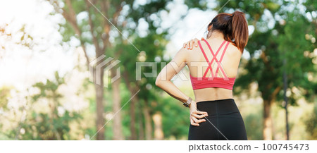 Young fitness woman holding her sports injury shoulder and neck, muscle painful during training. Asian runner female having body problem after exercise outside in summer Young fitness woman holding her sports injury shoulder and neck, muscle painful during training. Asian runner female having body problem after exercise outside in summer 100745473