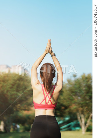 Young adult female in sportswear doing Yoga in the park outdoor, healthy woman sitting on grass and meditation with lotus pose in morning. wellness, fitness, exercise and work life balance concepts Young adult female in sportswear doing Yoga in the park outdoor, healthy woman sitting on grass and meditation with lotus pose in morning. wellness, fitness, exercise and work life balance concepts 100745517